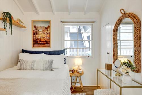1 Schlafzimmer mit einem weißen Bett und 2 Fenstern in der Unterkunft Balboa Island Beach Cottage in Newport Beach