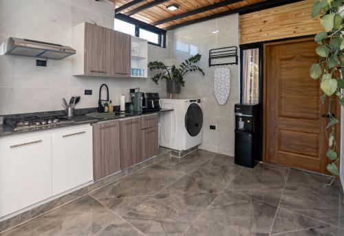 a kitchen with a sink and a stove and a refrigerator at Casa Ola & Surf in San Felipe de Puerto Plata