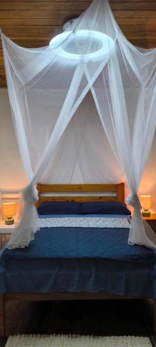 a bedroom with a bed with a mosquito net at Casa de Andréa in Santo António