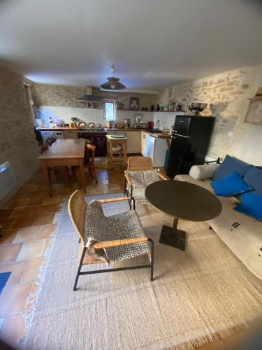 Una sala de estar con mesa y sillas y una cocina. en La malle bleue, en Vallabrix