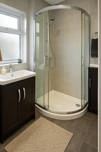 ein Badezimmer mit Dusche und Waschbecken in der Unterkunft Great for Contractors and Families 3BedHouse with FreeParking in Warrington