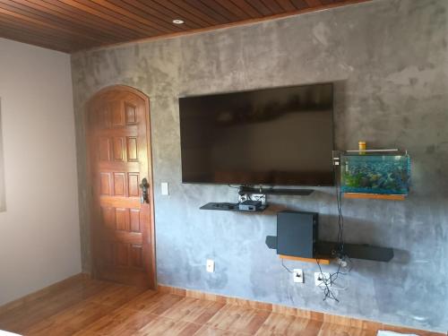 a wall with a flat screen tv on a wall at House available for the Rock the Mountain event in Petrópolis