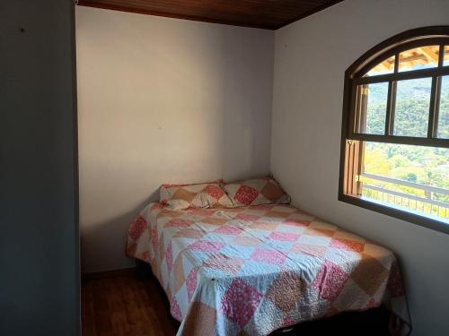 a small bedroom with a bed and a window at House available for the Rock the Mountain event in Petrópolis