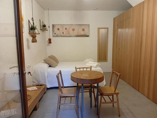a small room with a table and a bed at Ánimas, elegantes pisos en el centro histórico in Pontevedra