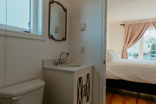 セントジョンズにあるSt Johns Retreat Terrace 3 BR & 2 Bathsの洗面台と鏡とベッドのあるバスルーム