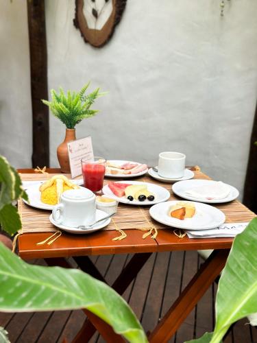 佩德拉斯港Loft Maruê Guesthouse Porto de Pedras的一张木桌，上面摆放着食物盘子