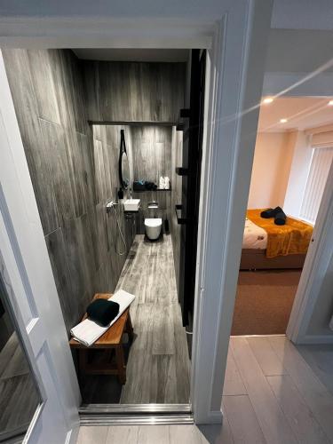 a bathroom with a shower and a toilet and a bed at Angel Cottage, Strone in Dunoon
