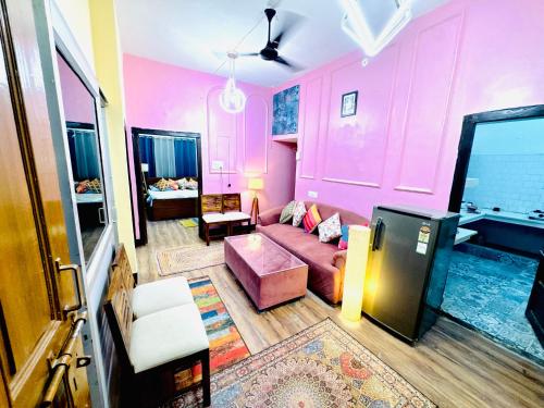 a living room with pink walls and a couch at The Family Courtyard, 5 Bed Room Boutique Villa and Guest Inn in Lucknow