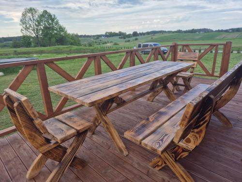 a wooden picnic table and chairs on a deck at Domek u Stasia in Połęczyno