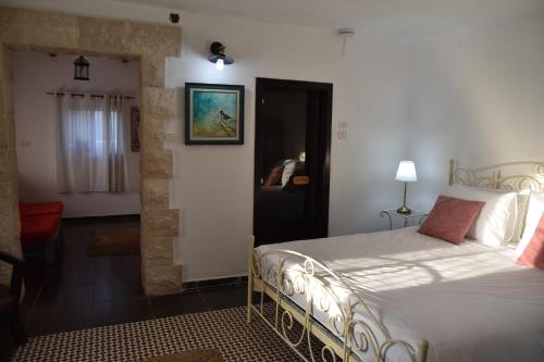 une chambre avec un grand lit et une pièce avec un couloir dans l'établissement Villa Corin, à Gornot HaGalil
