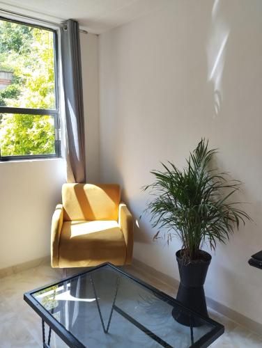 sala de estar con silla amarilla y mesa de cristal en Palacio de los Angeles, en San Felipe Hueyotlipan