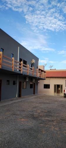 un edificio con balcón y aparcamiento en Alphaville Pousada e Hostel, en Bonito