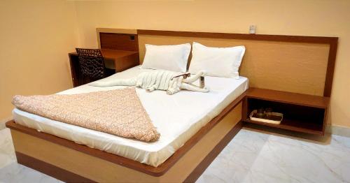 Un dormitorio con una cama grande con sábanas blancas. en Mandakini palace, en Varanasi