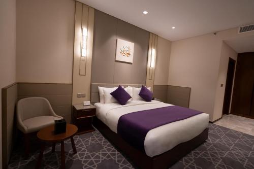 una habitación de hotel con una cama y una silla en Diar Alkhalidiya Hotel فندق ديار الخالدية, en La Meca