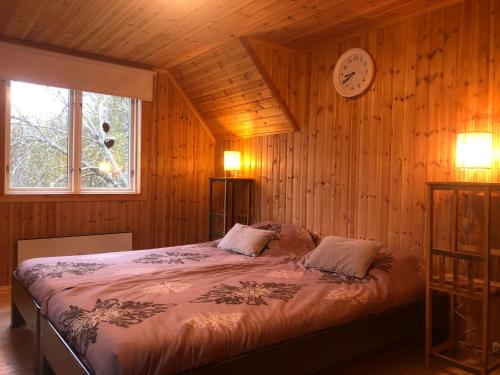 a bedroom with a bed with a clock on the wall at Elanden rust in Edebäck