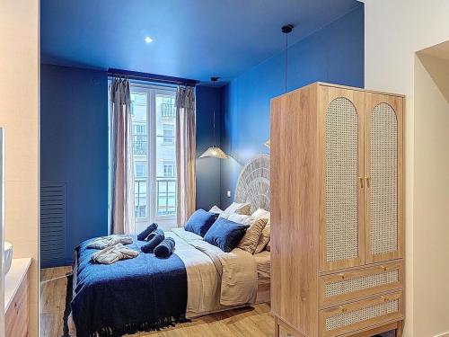 a blue bedroom with a bed and a dresser at Appart City break Chic Cosy Wifi Caen Hyper centre in Caen