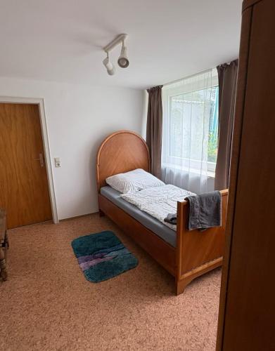 Un dormitorio pequeño con una cama y una ventana. en Room!Moor, en Schwarzenbach an der Saale