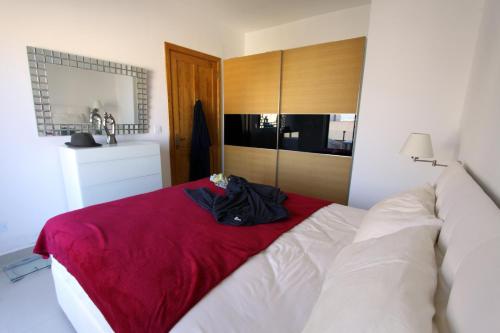 1 dormitorio con 1 cama con manta roja en Marble Arch en St Julian's