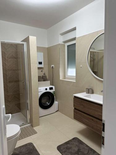 a bathroom with a washing machine and a sink at Apartman Kod Kestena in Osijek
