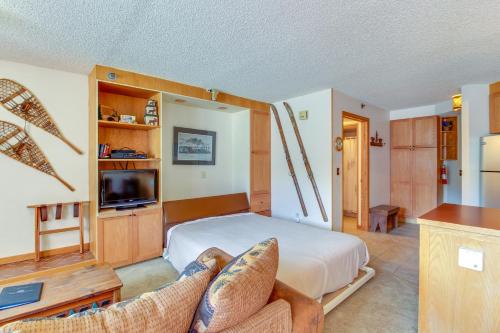 a bedroom with a bed and a tv and two chairs at Iron Horse Studio in Winter Park