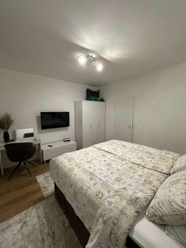 a bedroom with a large bed and a television at Apartman Kod Kestena in Osijek