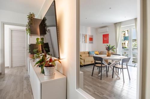 a living room with a dining room table and a mirror at Pomodoro House - Luminoso appartamento vicino Linate, Duomo, Fabrique, Unipol Dome in Milan