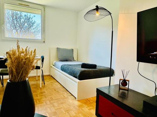 Zimmer mit einem Bett, einem Tisch und einem TV in der Unterkunft The Urban Stop - Apartment Near Paris & Disney in Noisy-le-Grand