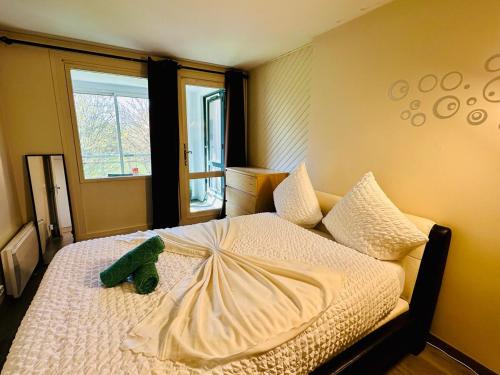 einem grünen Teddybär auf einem Bett in der Unterkunft The Urban Stop - Apartment Near Paris & Disney in Noisy-le-Grand