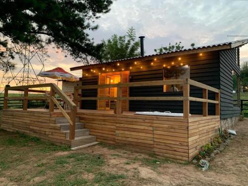 a house with a deck with lights on it at Cabana doce Luar in Gravataí