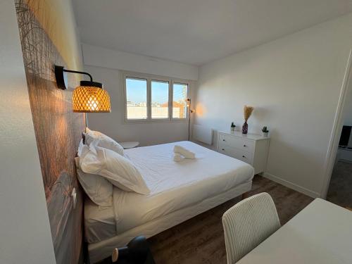 1 dormitorio con 1 cama con lámpara y mesa en Le Cocon de Port-Louis, en Port-Louis