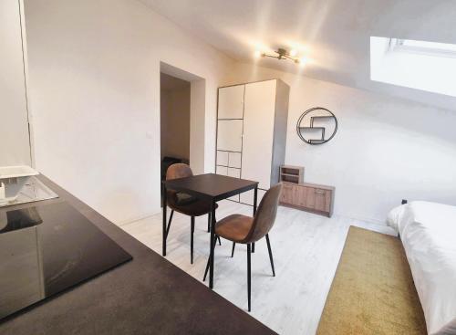 ランスにあるAstana - Concon confortable & Harmonieuxのテーブルと椅子2脚とベッドのある寝室