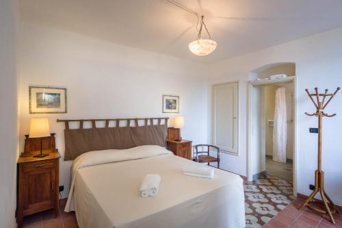 a bedroom with a bed with a white bedspread at Giardino in villa Margherita in Zoagli