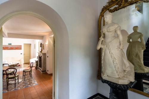 a statue of a woman on a wall next to a hallway at Giardino in villa Margherita in Zoagli