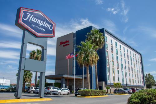 a hotel with a sign in front of a building at Hampton by Hilton Torreon Airport-Galerias in Torreón