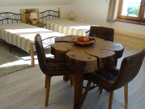 a room with a wooden table with a bowl of fruit on it at Na půdě in Pohořany