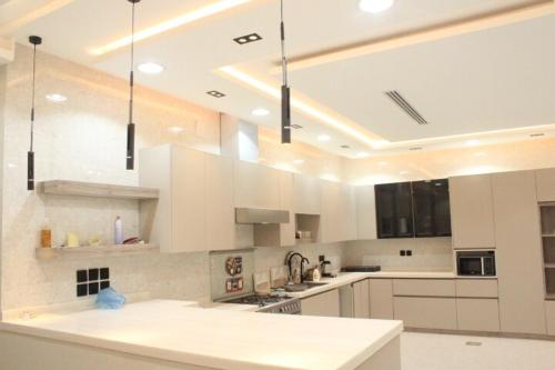 een grote witte keuken met witte kasten en apparaten bij فيلا راقية وسط المدينة in Az Zulfi