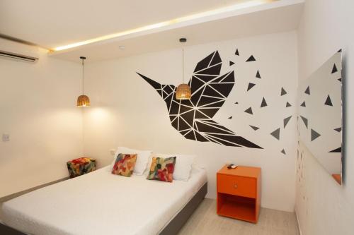 a bedroom with a bed and a painting on the wall at Hotel Barahona Cartagena in Cartagena de Indias