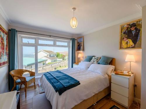 ein Schlafzimmer mit einem Bett und einem großen Fenster in der Unterkunft 4 Bed in Ogmore-By-Sea 87141 in Saint Brides Major