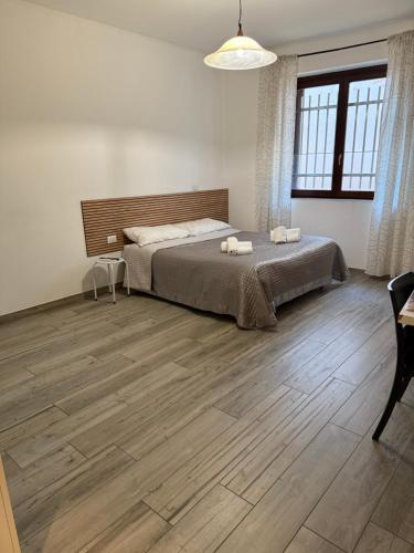 a bedroom with a bed and a wooden floor at La Maison di Vicolo Torre in Uboldo