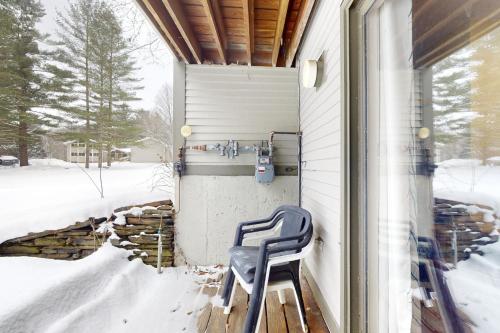 une chaise bleue assise sur un porche dans la neige dans l'établissement Mountain Breeze, à Warren
