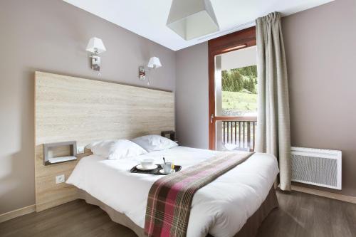 a bedroom with a large bed with a window at Résidence Odalys Le Panoramic in Flaine