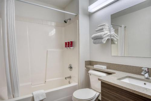 a white bathroom with a toilet and a sink at SureStay Plus Hotel by Best Western Lethbridge in Lethbridge
