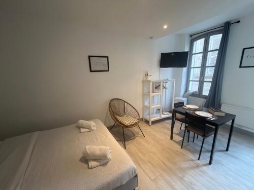 una camera da letto con un letto, una scrivania e un tavolo di Pia - Studio 1er climatisé 2 pers ad Avignone