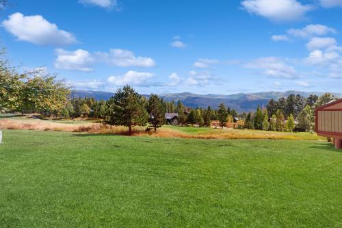 un campo verde con un granero y montañas al fondo en Tamarron Lodge #753, en Rockwood