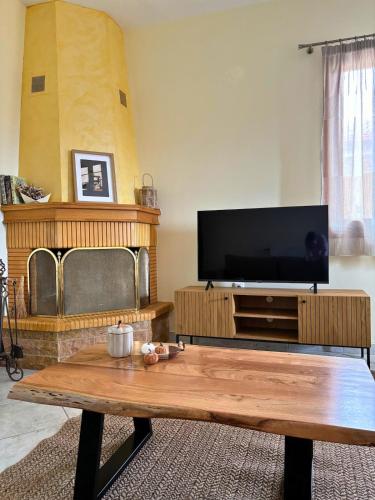a living room with a tv and a wooden coffee table at Chimpanzee Forest House in Karpenisi