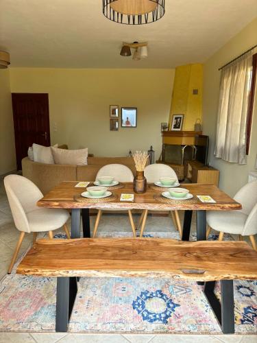 a wooden table with chairs and a living room at Chimpanzee Forest House in Karpenisi