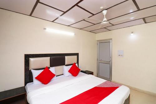 ダラムシャーラーにあるSuper Hotel O Country Lodgeのベッドルーム1室(大型ベッド1台、赤い枕付)
