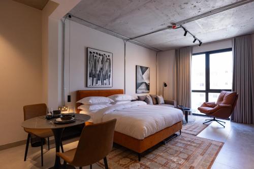 a bedroom with a bed and a table and chairs at C Living 3 - Al Malqa in Riyadh