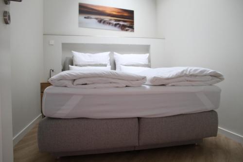 a bed with white sheets and pillows on top at Apartment in Berlin-Köpenick in Berlin