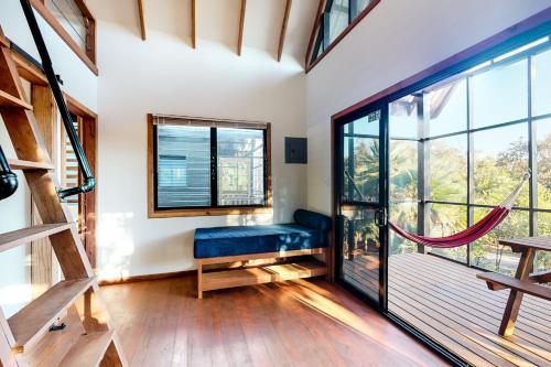 a room with a blue bench and a large window at Toucan Cabaña at Inn The Trees -Gold Standard Certified in Seine Bight Village